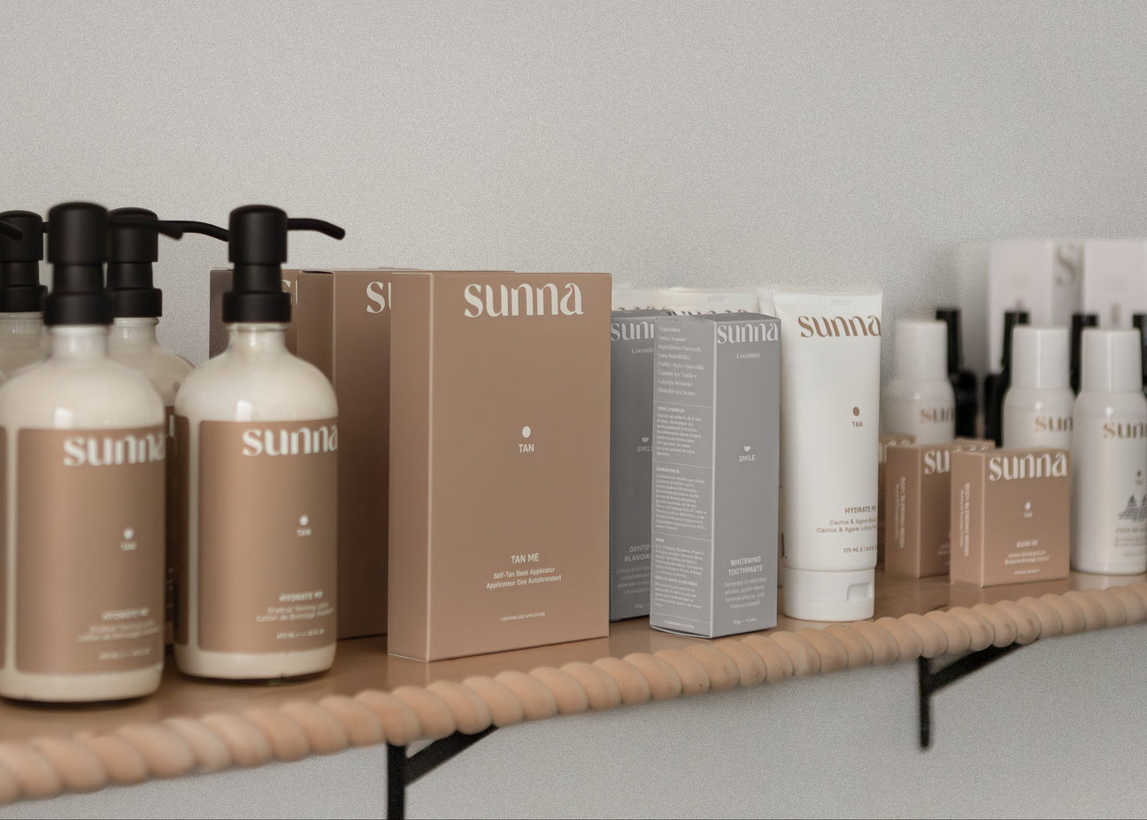 Lineup of SUNNA products on a shelf against a plain wall.